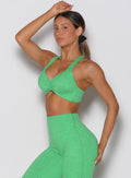 front left side shot of a model with one hand resting on top of her head wearing the Hyper form bra in Neon Miami Beach color