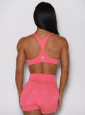 A rear view of the model wearing our Hyper Form Bra in Neon Tangerine Punch.
