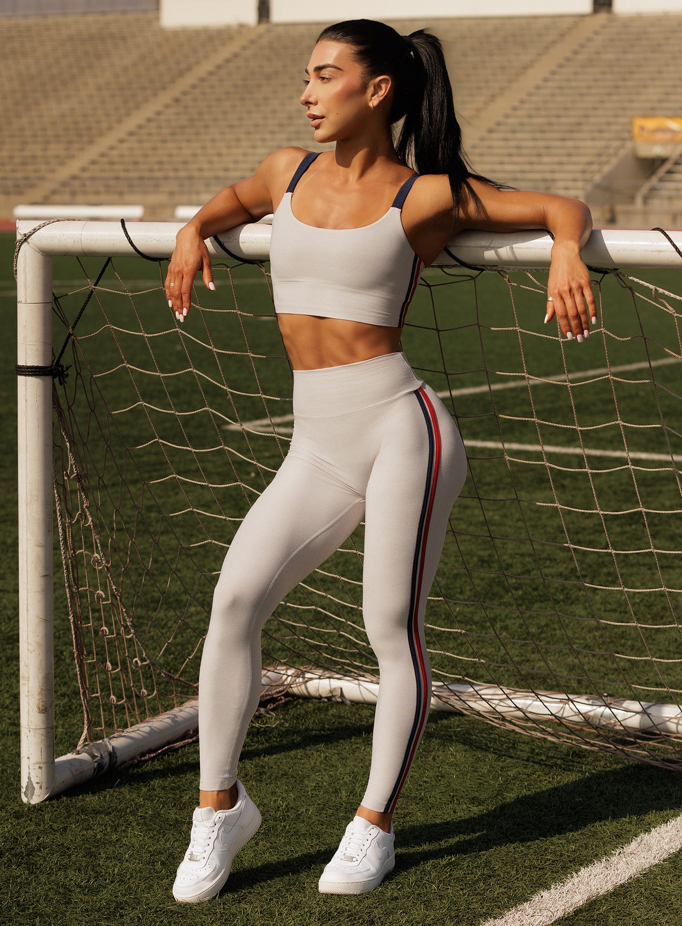 Ice Power Play leggings with sculpting support and bold side stripes on the training field