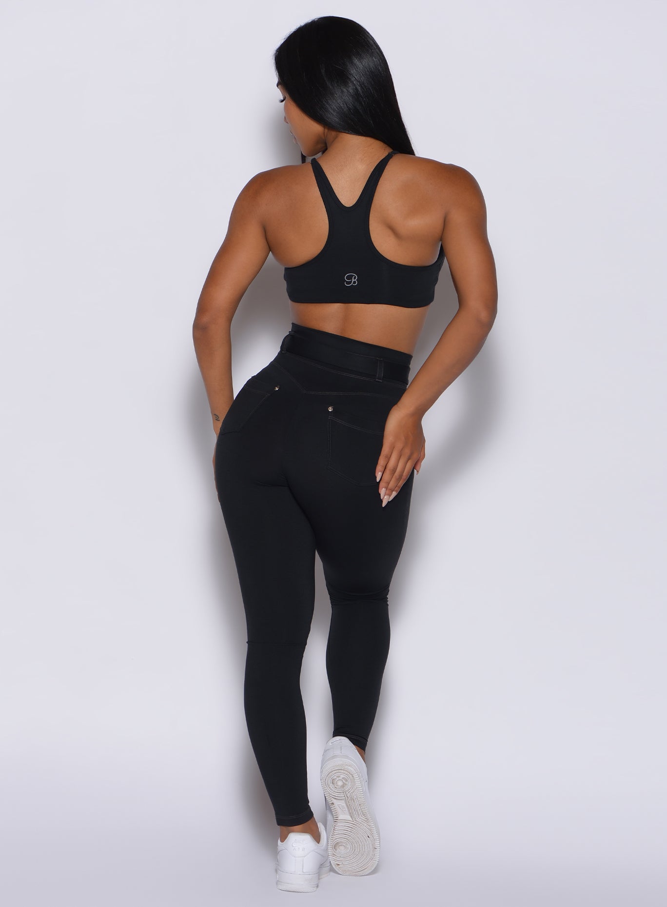 back profile view of a model wearing our black peach bottoms leggings along with the matching sports bra