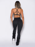 back profile view of a model wearing the Luxe Leg Warmers in black color
