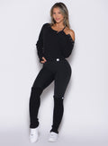 front profile view of a model wearing the Luxe Leg Warmers in black color paired with the matching top and leggings