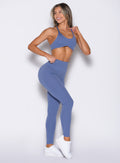 front right side profile view of a model looking to the back wearing the Internal Scrunch Leggings in blue chill color