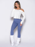 front profile view of a model with one hand on her thigh wearing the Luxe Leg Warmers in white color