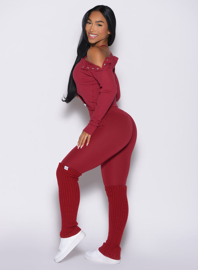 left side profile view of a model wearing the Luxe Leg Warmers in red velvet color paired with the matching leggings and top