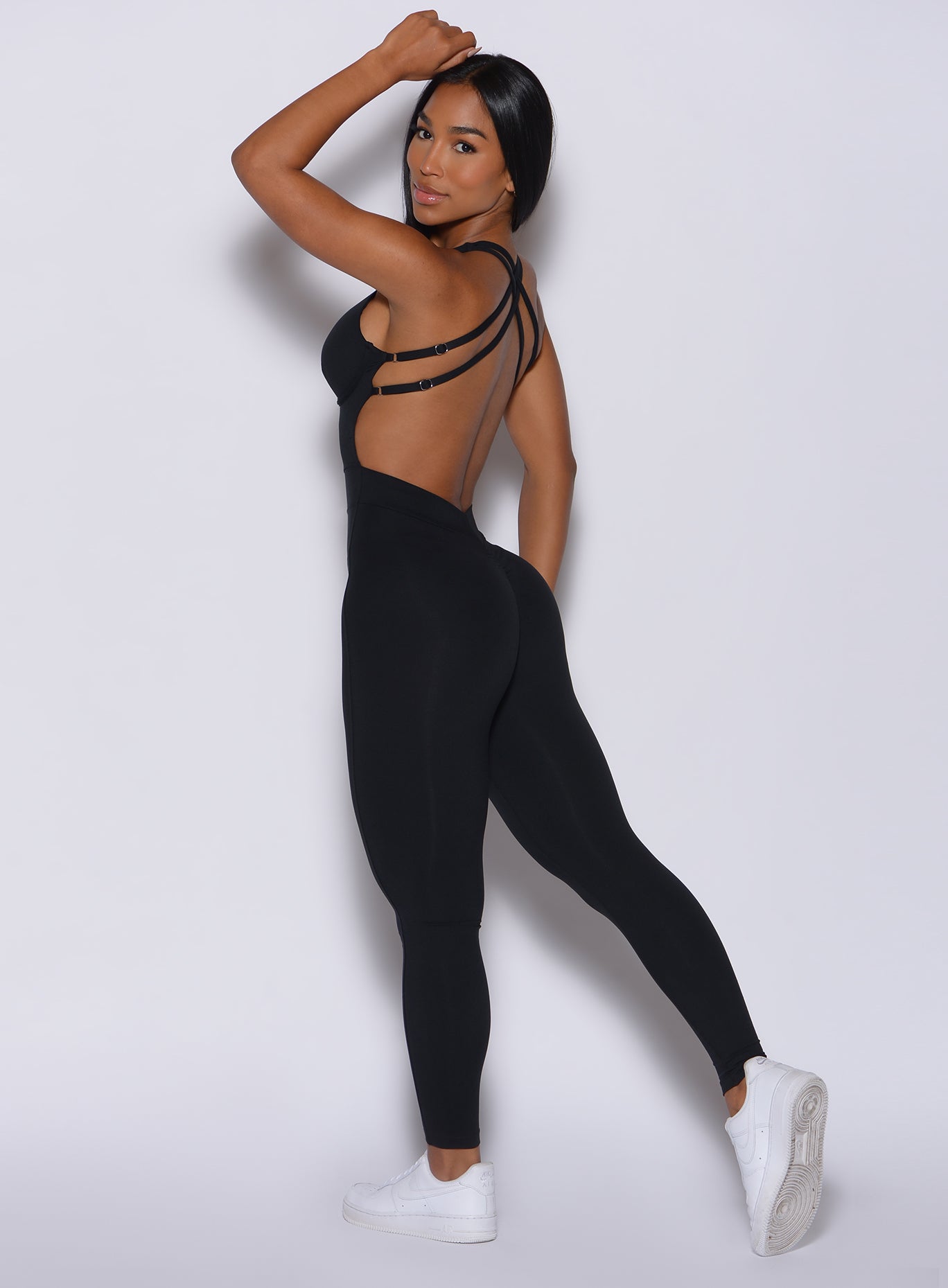 Left side profile view of a model wearing our black Bombshell Bodysuit