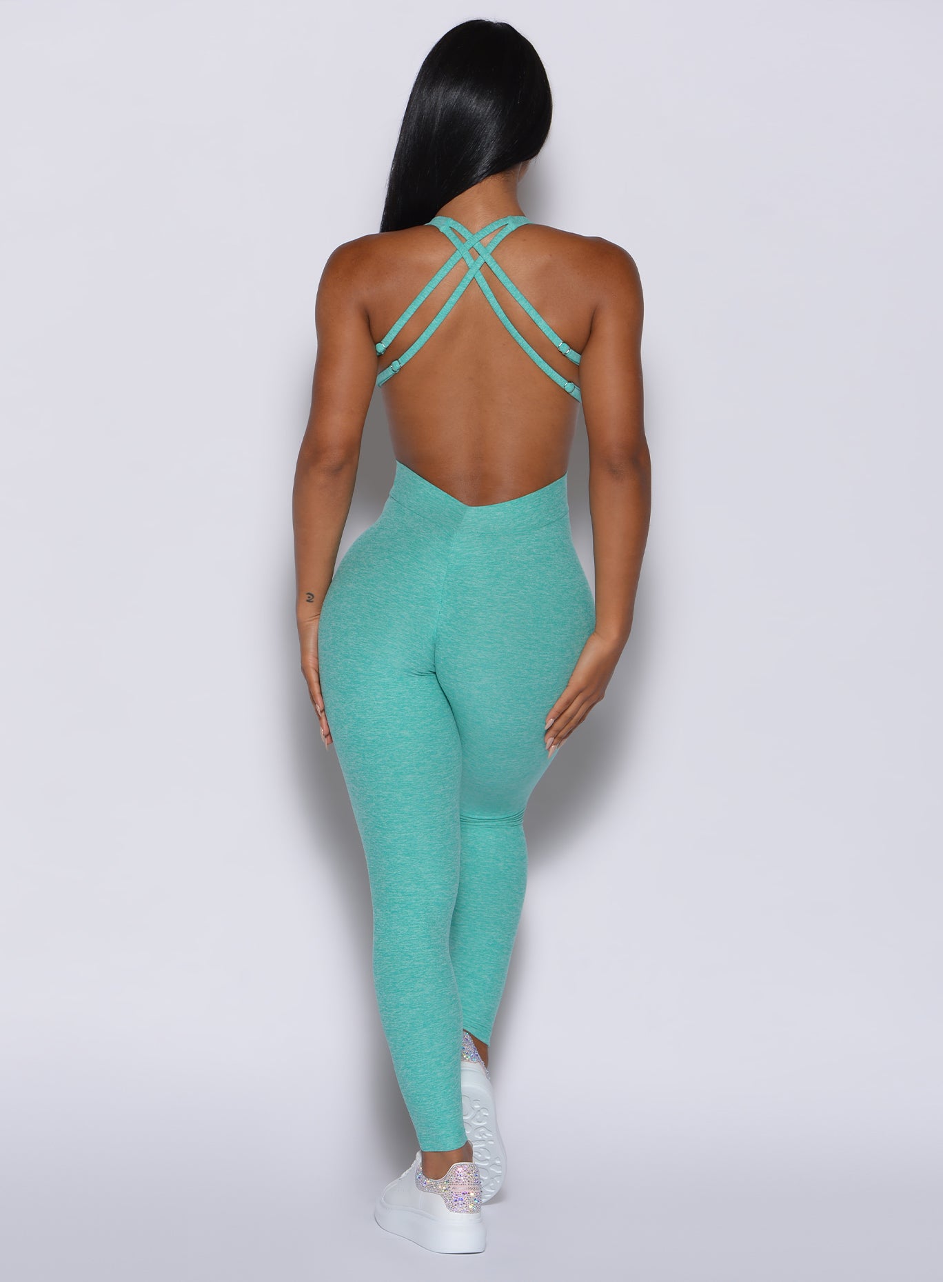 Back profile view of a model wearing our mint bombshell bodysuit