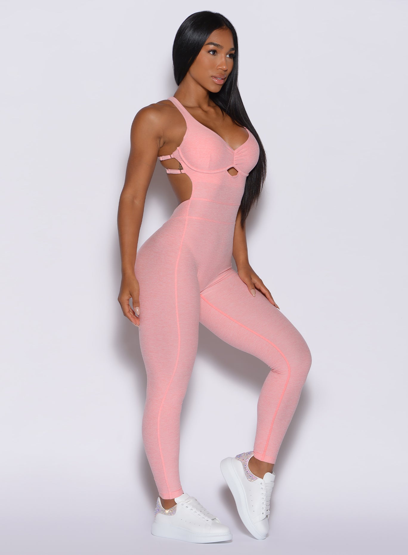 Right side profile view of a model in our bombshell bodysuit in peachy pink