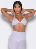 front profile view of a model in a hair tying pose wearing the Kini Bra in Galactic Lilac color