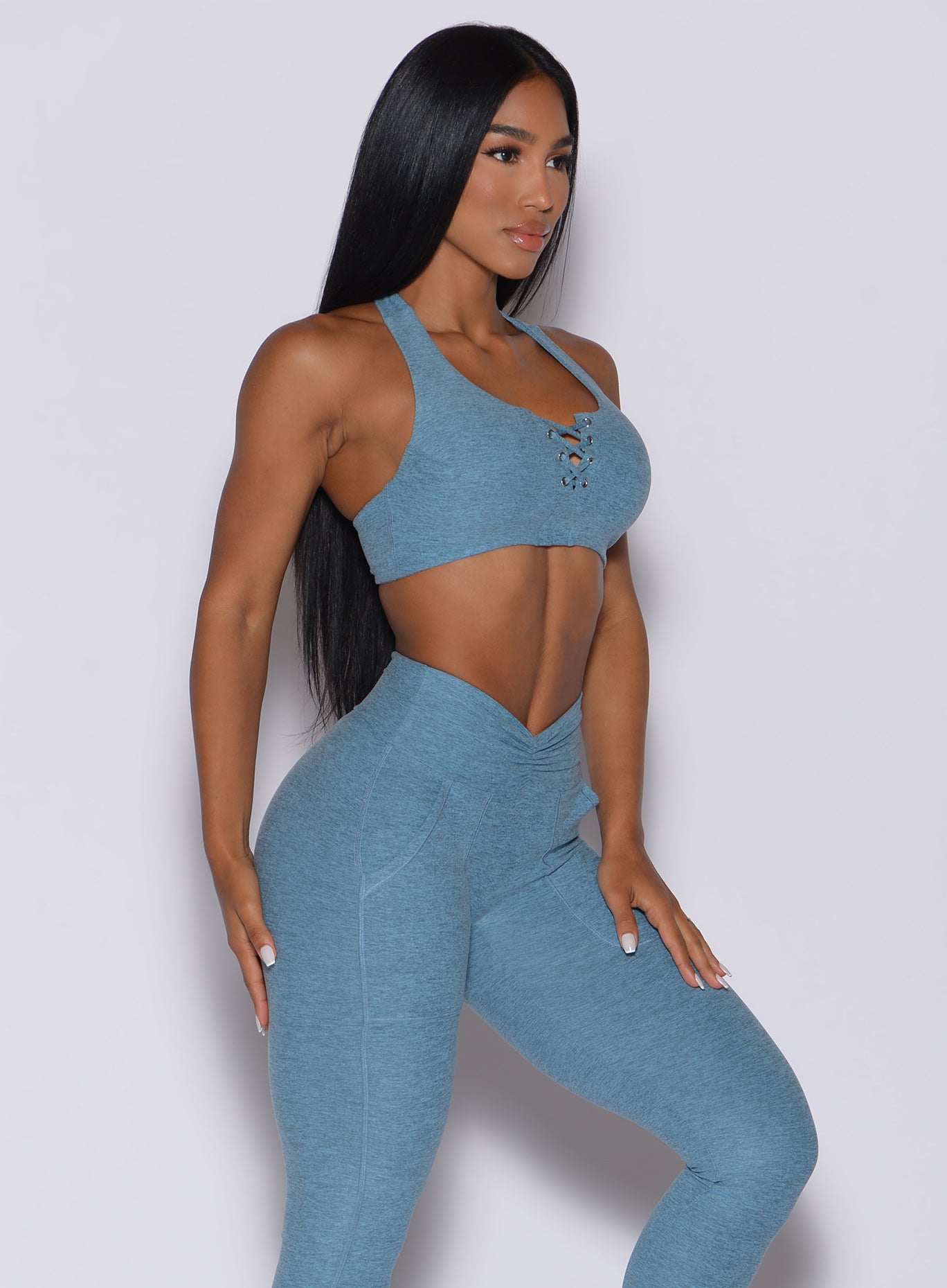 Right side profile picture of a model in our laced crop bra in baby blue color and a matching leggings