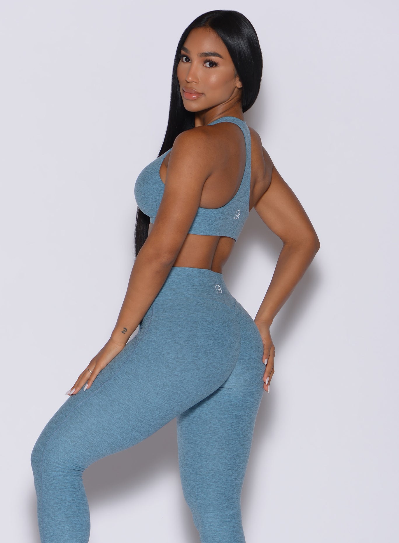 Left side profile view of a model facing to her left wearing  our laced crop bra in baby blue color and a matching leggings