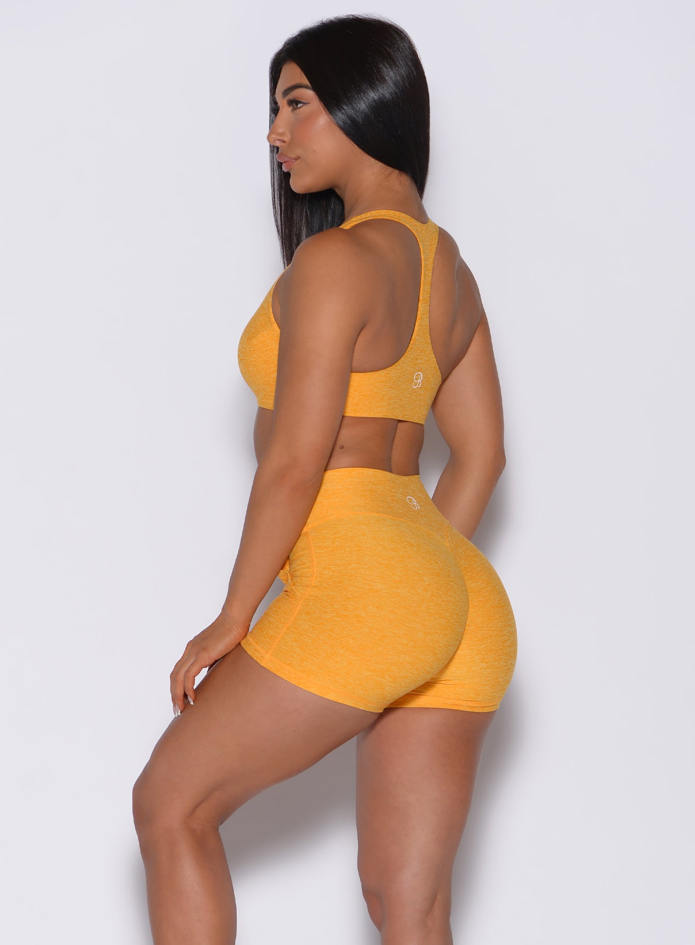 Left side  profile view of a model in our laced crop bra in sunkissed color and a matching shorts