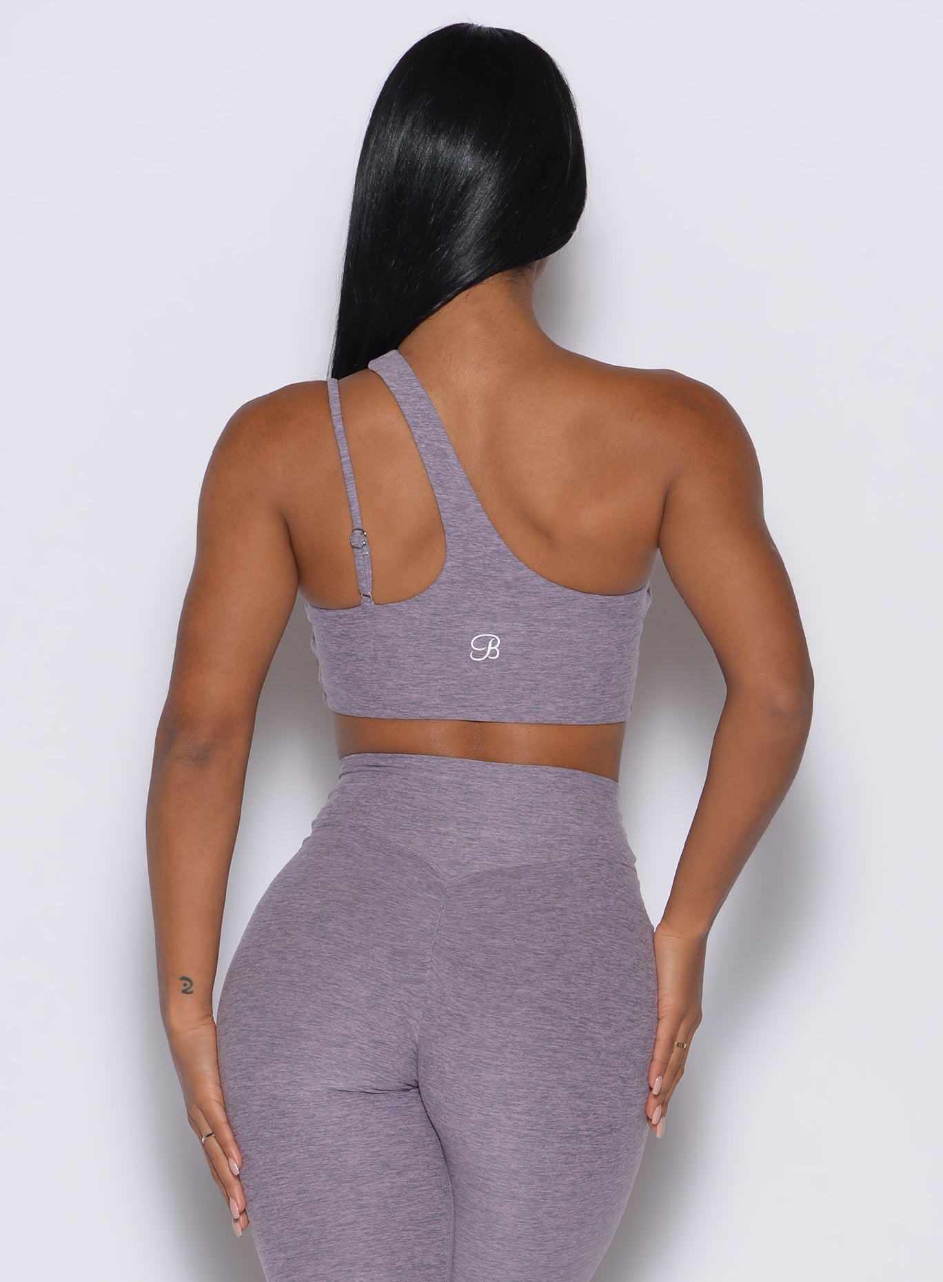back profile view of a model wearing our lateral top in Lilac Grey along with a matching leggings