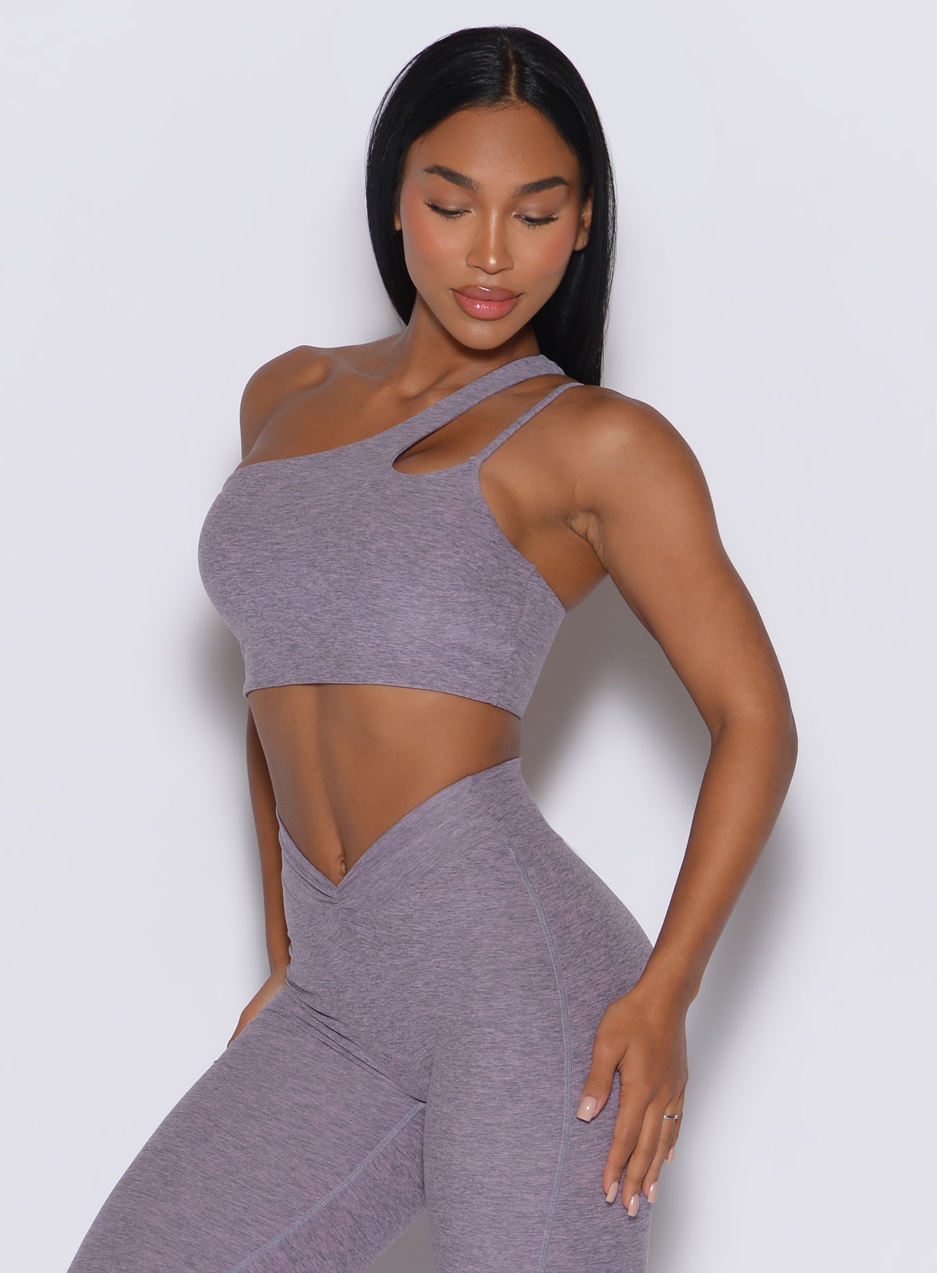 front profile view of a model wearing our lateral top in Lilac Grey along with a matching leggings 