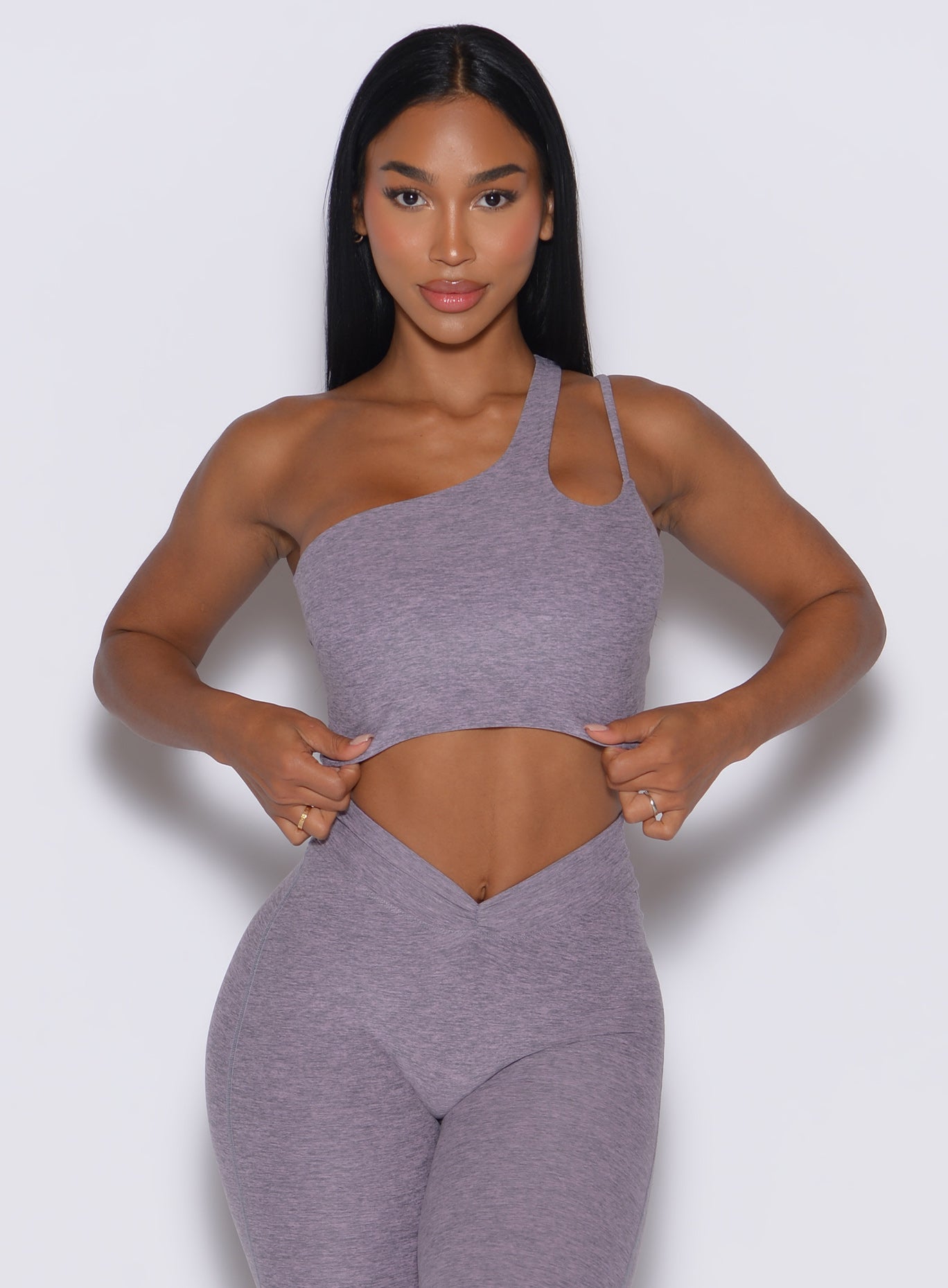 front profile view of a model facing forward wearing our lateral top in Lilac Grey along with a matching leggings