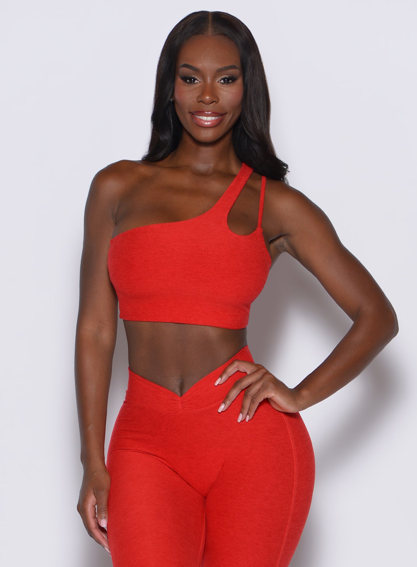 front  profile view of a model in our lateral top in Scarlet Red along with a matching leggings