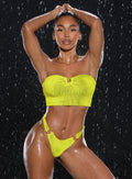 front profile view of a model in indoors and  water droplets falling around her with both hands resting on top of her head wearing the Neon Nights Bikini Bandeau in Lemon Drop color