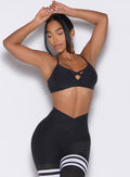 front profile view of a model wearing the Lift Luxe Sports bra in Heathered black color paired with the matching leggings 