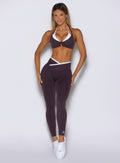 front profile view of a model with both hands on her thighs wearing the Line Contour Leggings in black orchid color 