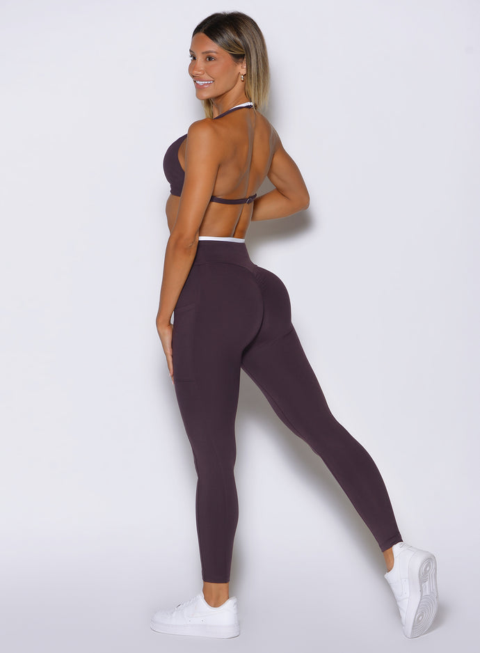 back left side profile view of a model wearing the Line Contour Leggings in black orchid color 