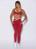 front profile view of a model with both hands in the side pockets wearing the Line Contour Leggings in maroon color 