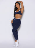 front profile view of a model with one hand resting on top of her head wearing the Line Contour Leggings in navy color 