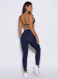 back profile view of a model facing to the right side wearing the Line Contour Leggings in navy color 