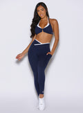 front view of a model with one hand inside the side pocket wearing the Line Contour Leggings in navy color 