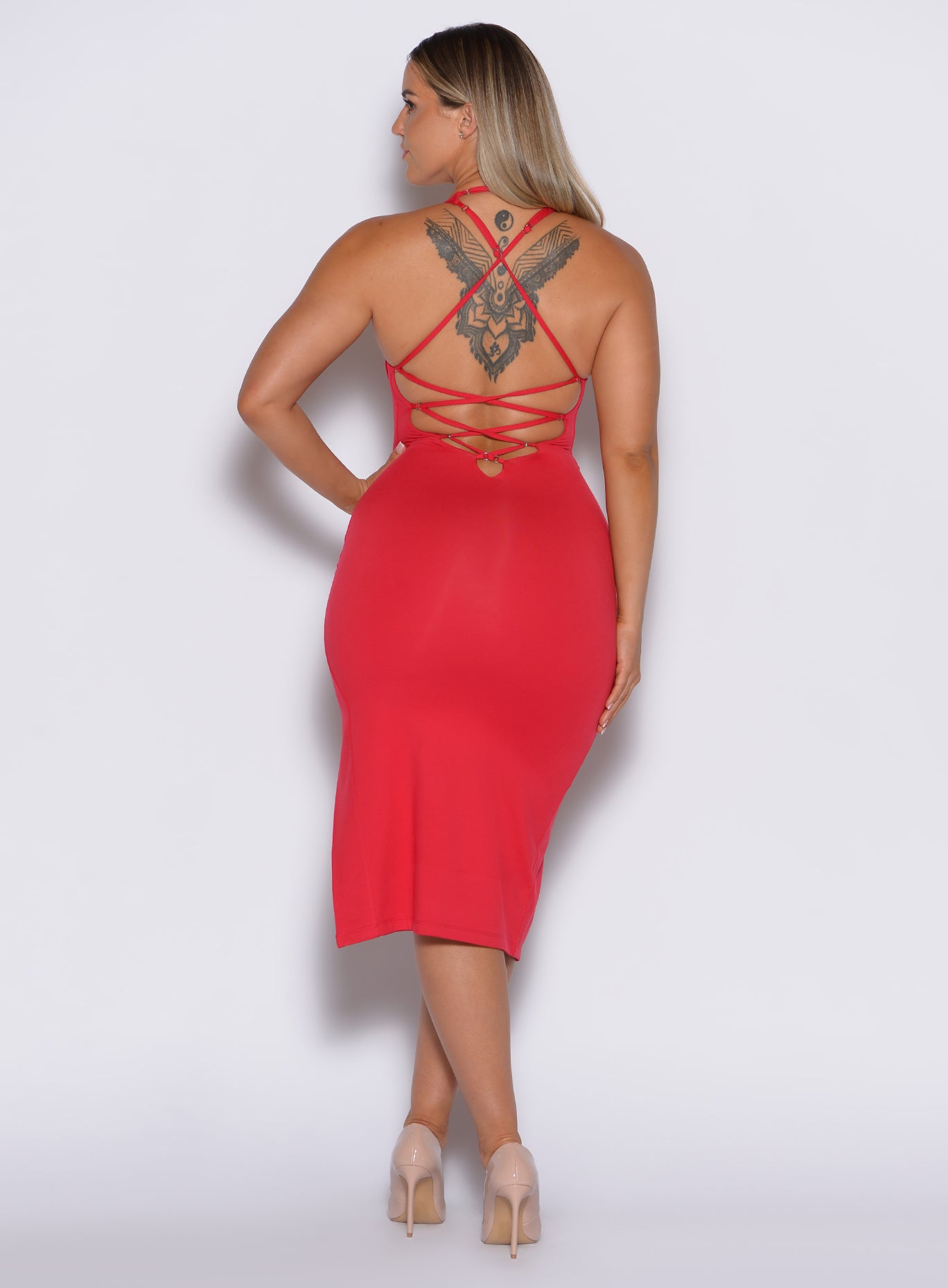 back profile view of a model facing to her left wearing our bright red dress with criss cross adjustable straps at the back