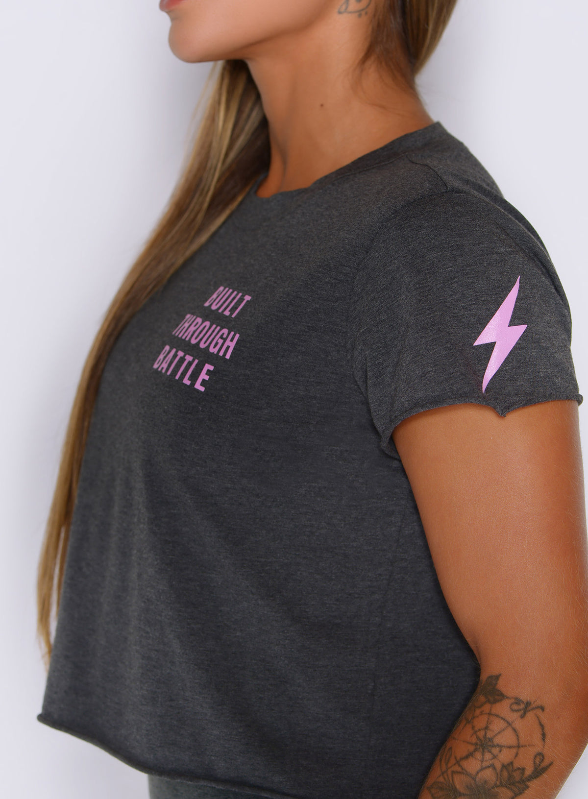 Side perspective of The Lover Fighter Tee in Charcoal with pink lightning graphic and cropped cut.