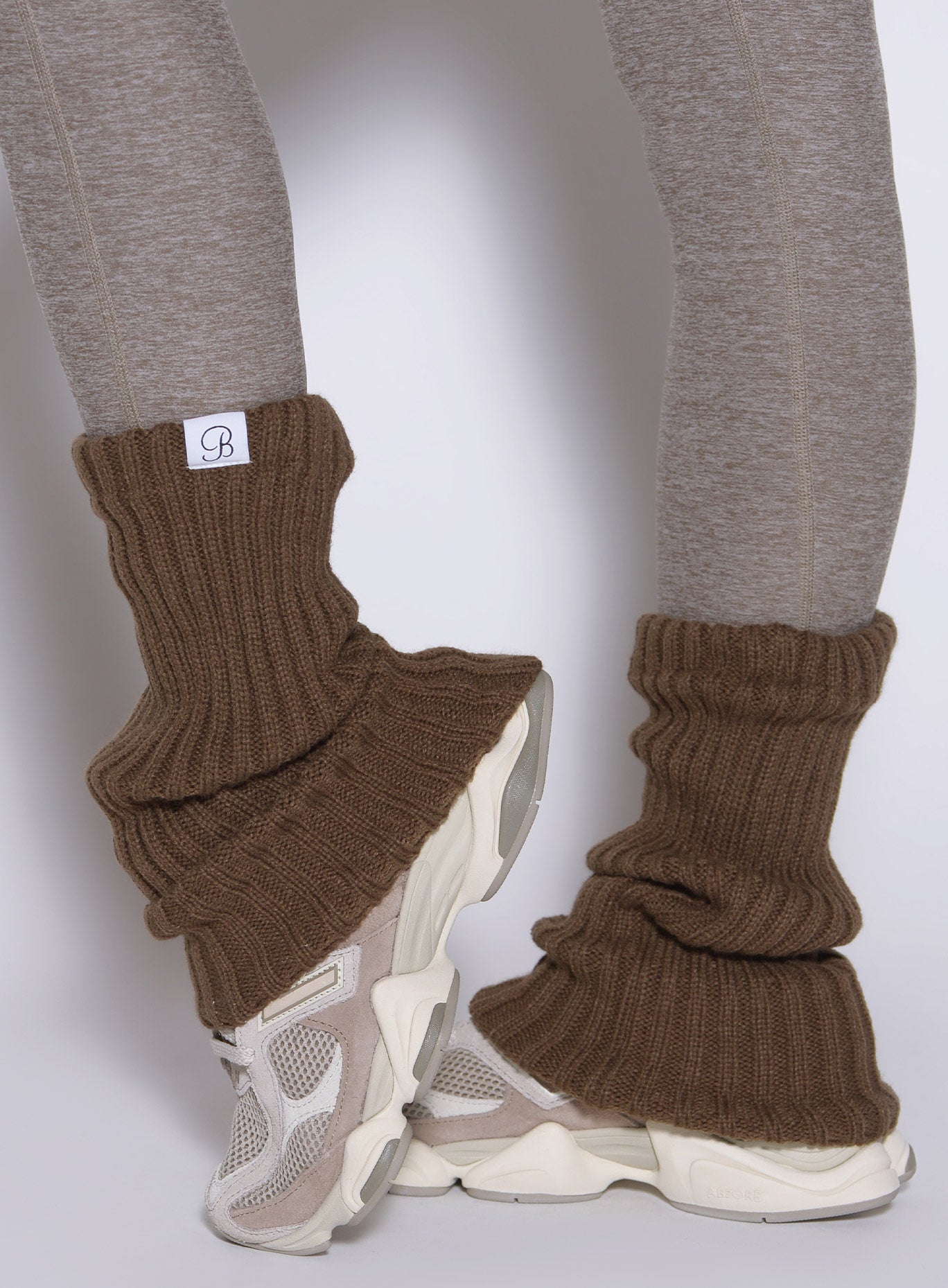 close up left side view of a model wearing the Luxe Leg warmers-short in smoked taupe color