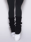 close up front profile view of a model wearing the Luxe Leg Warmers in black color