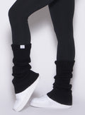 left side close up view of a model wearing the Luxe Leg Warmers in black color