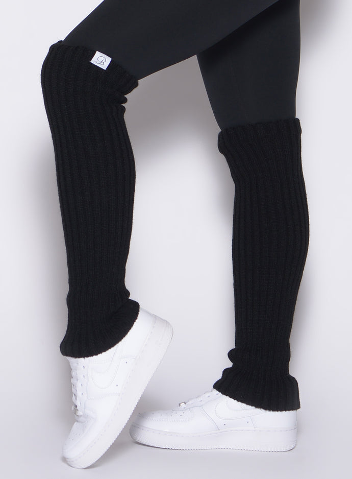 left side view of a model wearing the Luxe Leg Warmers in black color