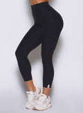 close up left side view of a model wearing the Movement 7/8 Leggings in heathered black color