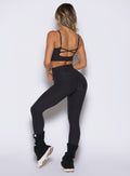 back left side profile view of a model wearing the Movement 7/8 Leggings in heathered black color
