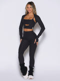 front profile view of a model wearing the Movement 7/8 Leggings in heathered black color paired with the matching tops 