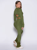 right side view of a model looking over her shoulders wearing the Luxe Leg warmers-short in Juniper color