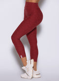 close up left side view of a model wearing the Movement 7/8 Leggings in rouge color