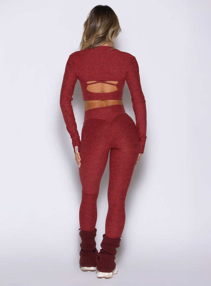 back side view of a model wearing the Movement 7/8 Leggings in rouge color paired with the matching tops 