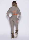 back side view of a model wearing the Luxe Leg warmers-short in smoked taupe color paired with the matching tops and leggings