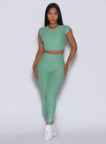 Model facing forward wearing our Movement Leggings in Sage color and a matching Tee