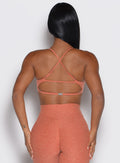 back view of a model showcasing the multi-way tie straps on the MulTie Sports Bra in spiced maple color