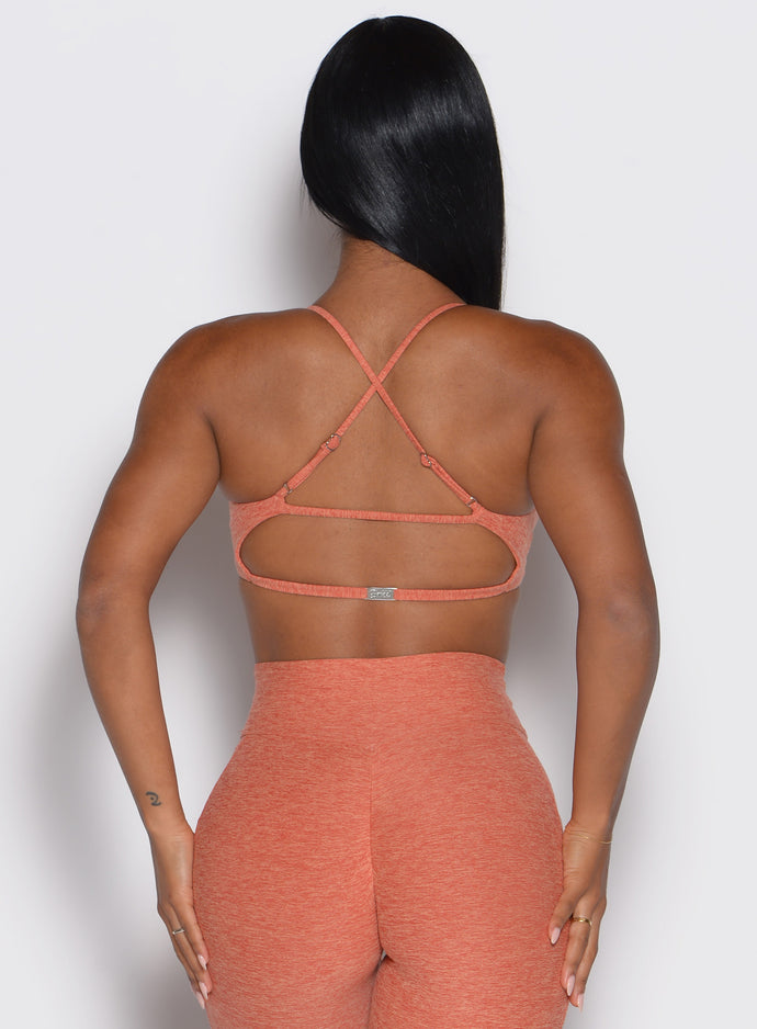 back view of a model showcasing the multi-way tie straps on the MulTie Sports Bra in spiced maple color