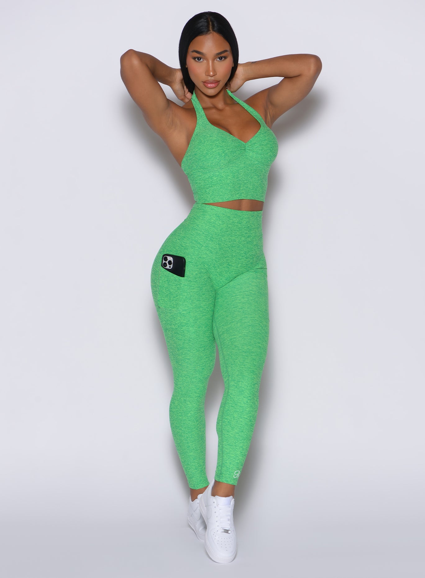 front profile picture of a model wearing our V back leggings in Neon Miami Beach color along with a matching bra