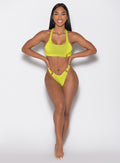 front profile view of a model with both hands on her waist wearing the Neon Nights Bikini Bottoms in Lemon Drop color 