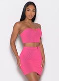 front right side profile view of a model wearing the Neon Nights Bikini Bandeau in Pink Passion color paired with the matching skirt