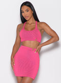 front profile view of a model with one hand on her waist wearing the Neon Nights Bikini Top in Pink Passion color