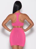back profile view of a model with both hands on her waist wearing the Neon Nights Bikini Top in Pink Passion color