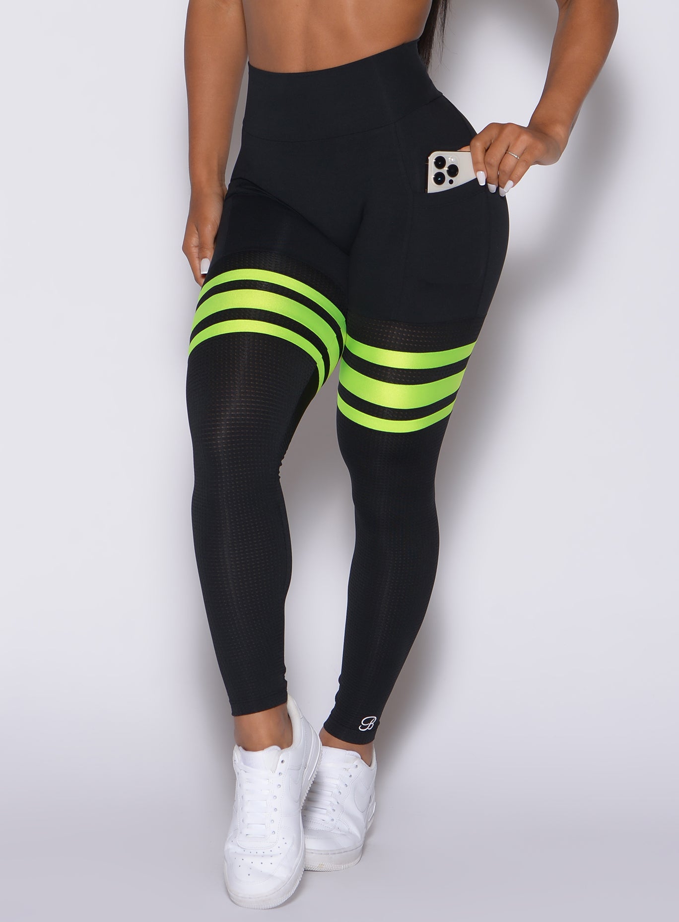 Zoomed in front view of our scrunch thigh high in black with neon yellow stripes 